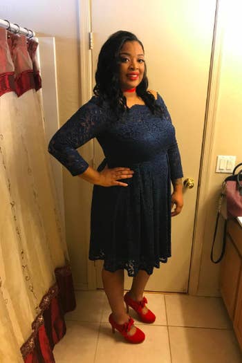 A reviewer wearing the knee-length dress in navy blue