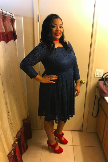 A reviewer wearing the knee-length dress in navy blue