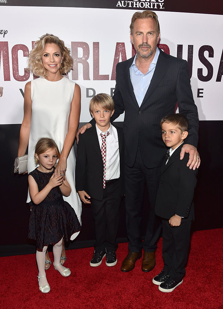 Kevin Costner on the red carpet with his family and arms around two young boys