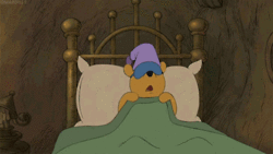 GIF of winnie the pooh snuggling up in bed