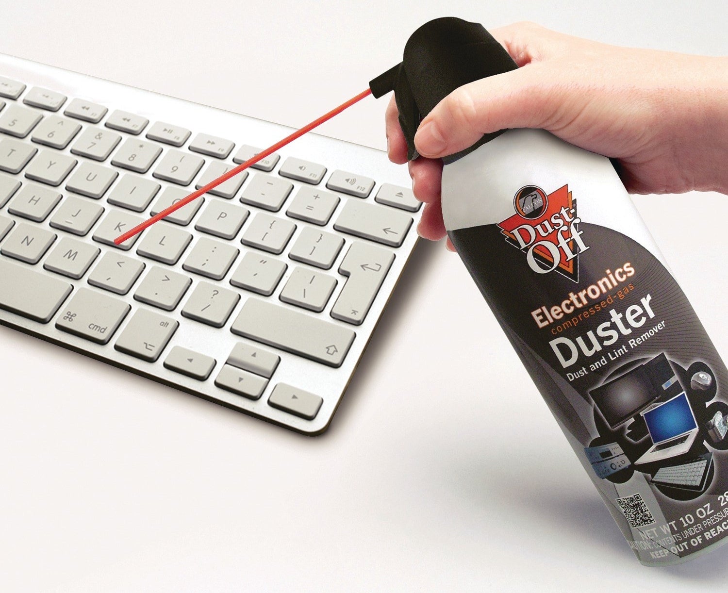 A can of Dust Off being used to clean an Apple keyboard
