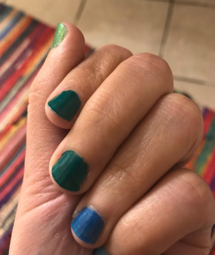 hand with different colored polishes on each nail