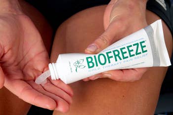 A person squeezing a tube of Biofreeze onto their fingers