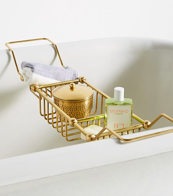 gold piping caddy hanging from the edges of the bathtub