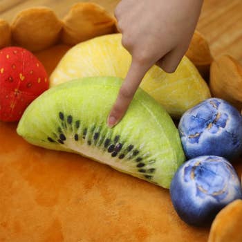 The fruit-shaped plushies that come with the bed
