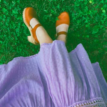 reviewer's feet in clogs with dress on clover