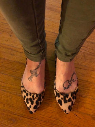 A reviewer wearing the pointed-toe flats in a leopard print pattern 