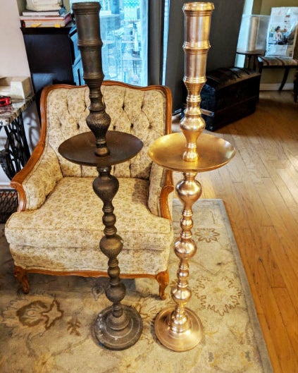 Two candle sticks side by side; one having been treated with the product and looking brand new and the other still rusted over 