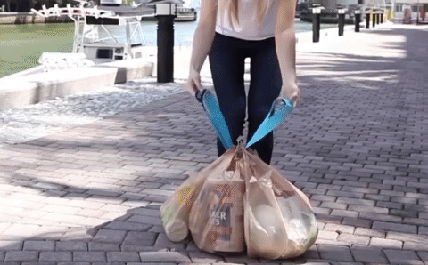 gif of model wrapping looped strap around multiple plastic shopping bags to pick them all up at once