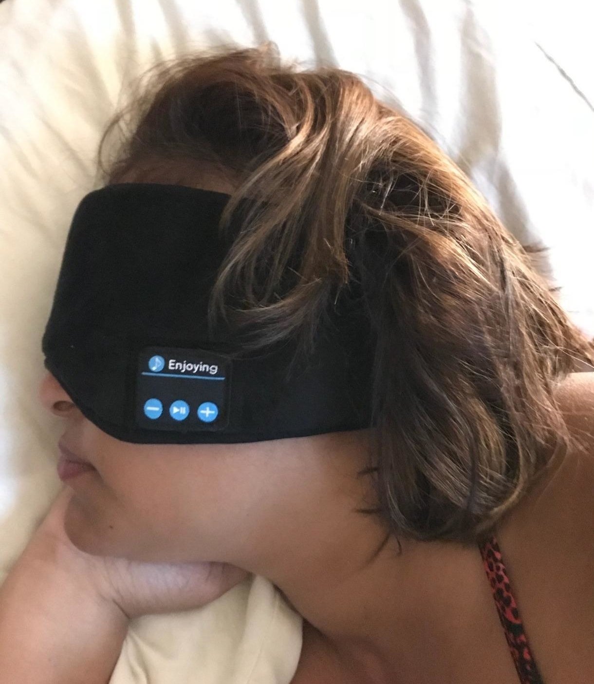 reviewer in eye mask with wide band that covers the ears