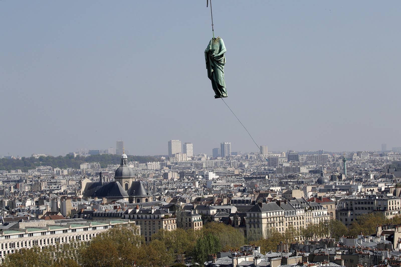 A statue of Saint John is removed from the spire of Notre Dame Cathedral by a crane before restoration work on April 11, 2019.