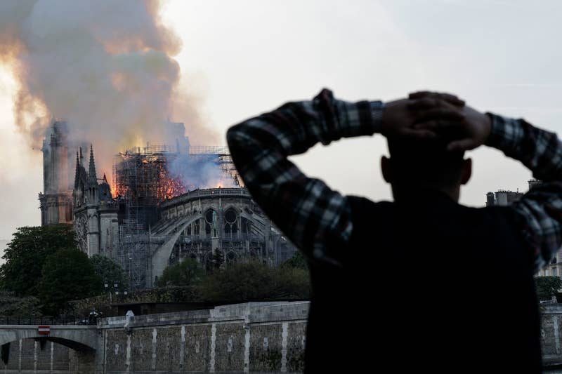 A man watches the landmark Notre Dame Cathedral burn.