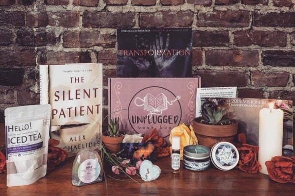 a box that says &quot;unplugged&quot; surrounded by a book, candles, tea, and more items