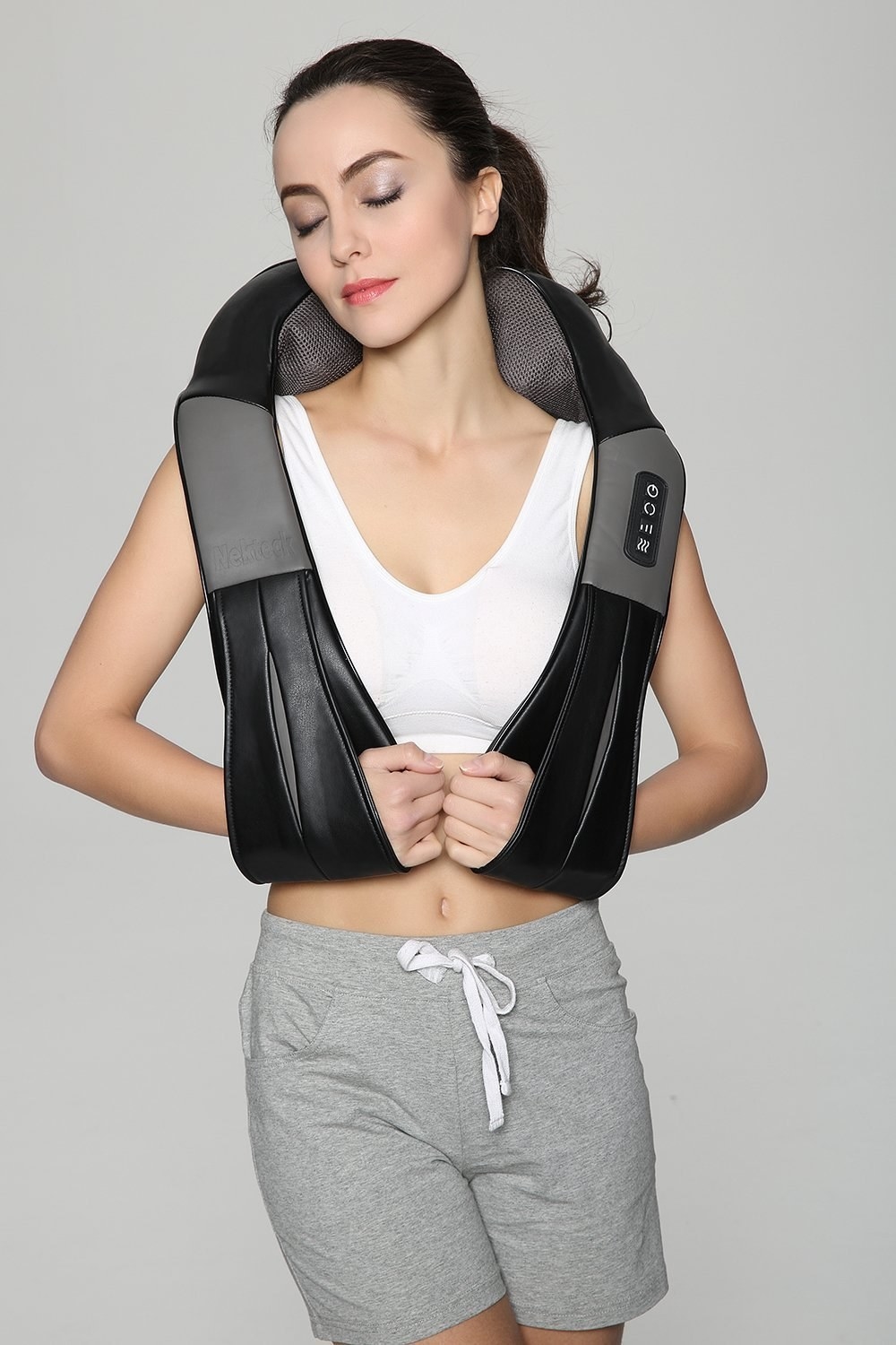 A model with the shoulder massage across their back and their arms in the straps in front of their body