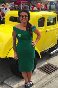 reviewer pic wearing the green dress in front of a vintage car