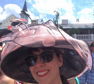 a reviewer in an oversized hat covered in organza