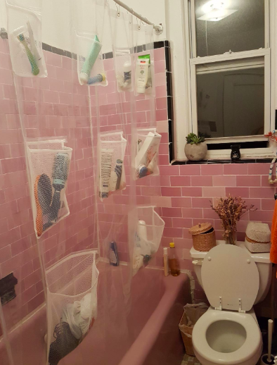 Reviewer photo of shower curtain liner with pockets filled with toiletries