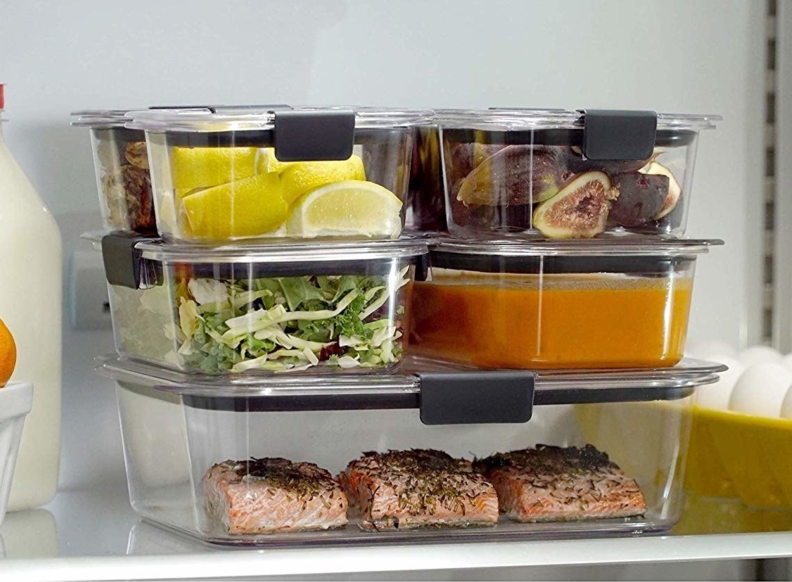 stack of clear food storage containers in a fridge