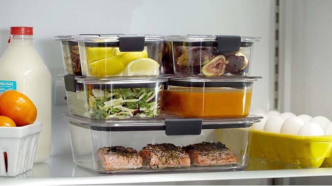 stack of clear food storage containers in a fridge