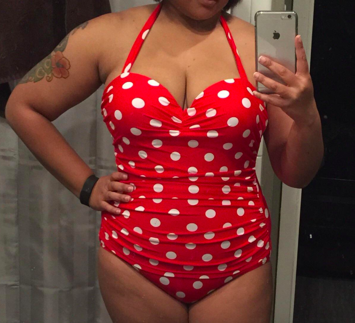 reviewer wearing the halter swimsuit in red with white polka dots 