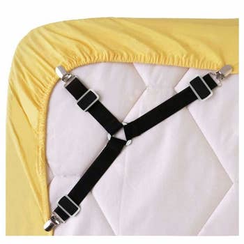 the fasteners, which look like a three-pronged overall strap, holding a fitted sheet around the underside of a mattress