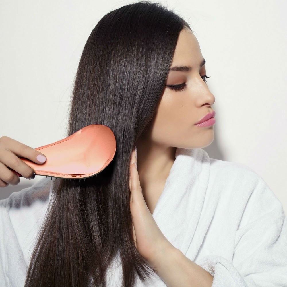 Model brushing hair with detangling brush