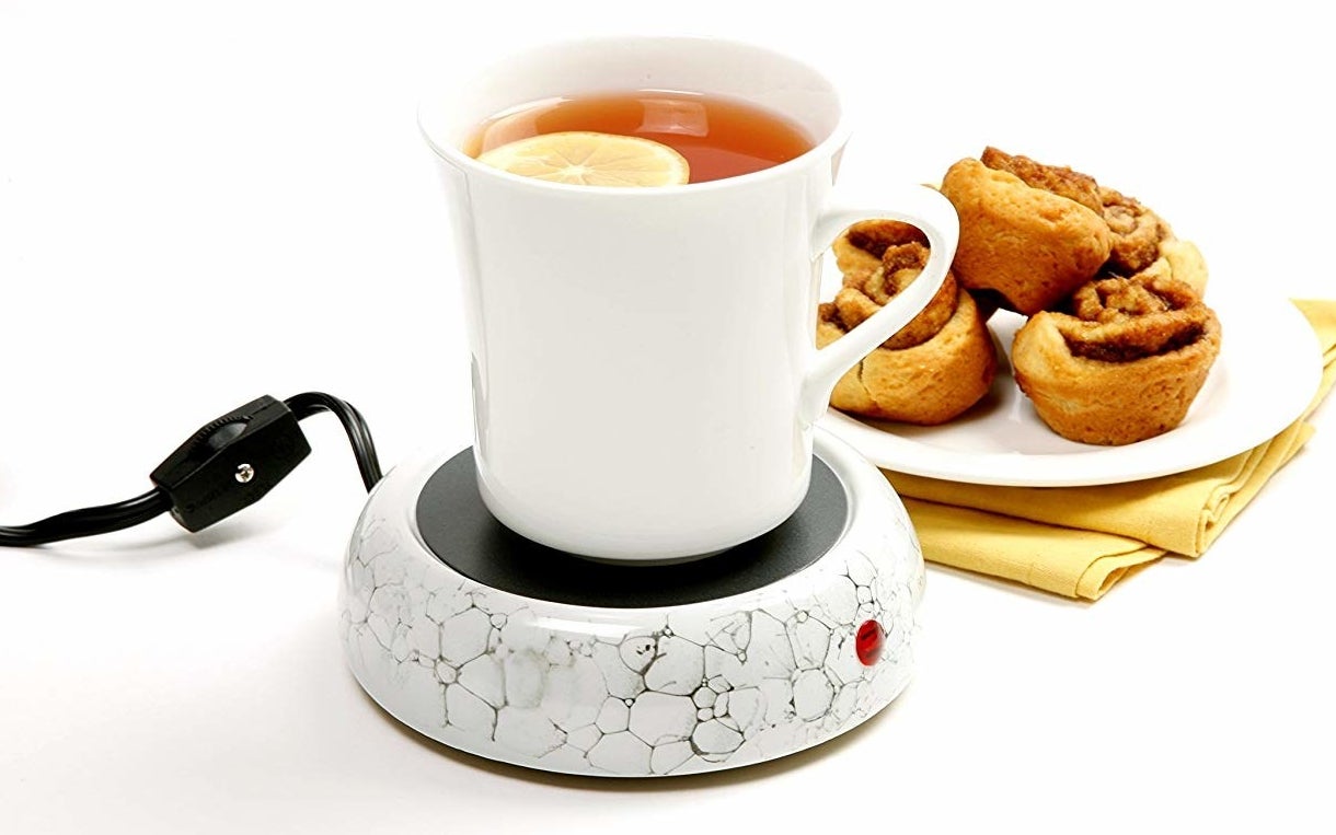 Cup of tea placed on ceramic mug warmer