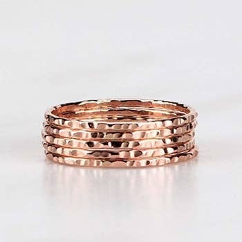 a stack of hammered rose gold rings