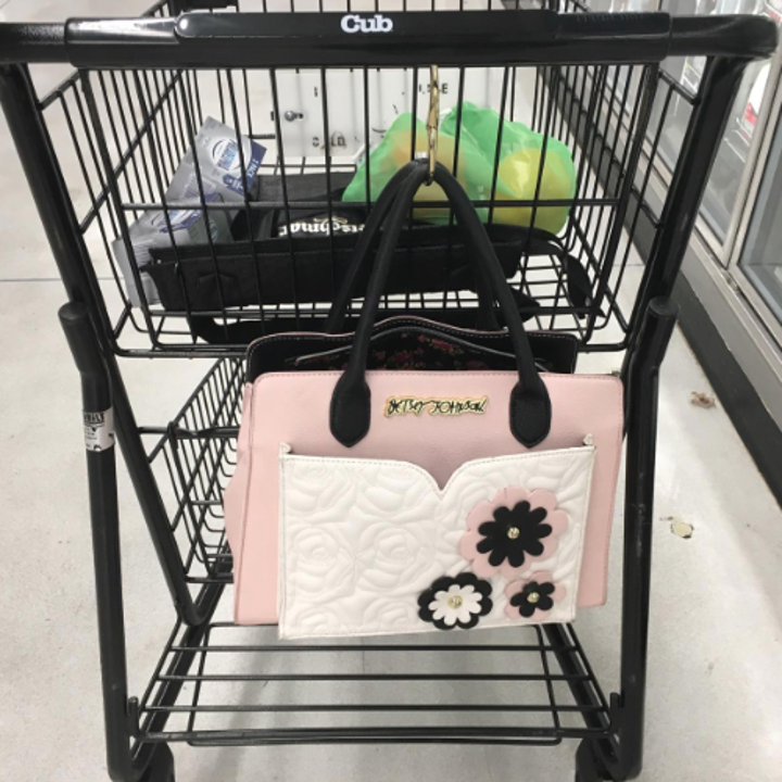 A reviewer photo of purse hanging from a shopping cart 