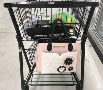reviewer photo of purse hanging from a shopping cart 