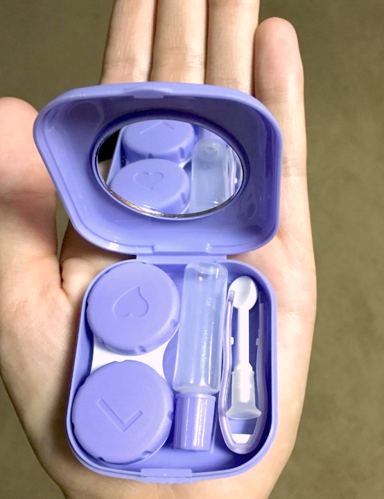 reviewer holding the tiny contact case