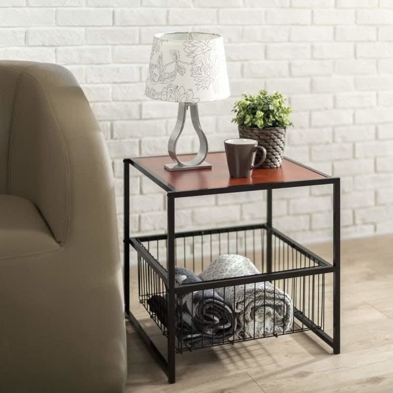 the end table with wood top and black frame and a wire basket on the bottom