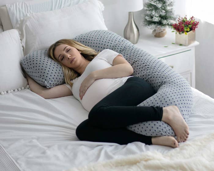 pregnant person sleeping on the side cradled in the C-shaped pillow
