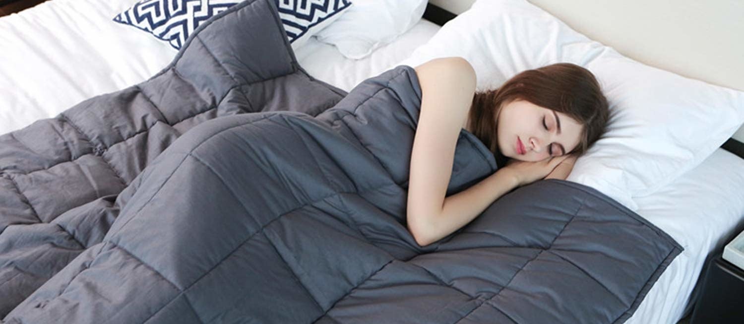 person sleeping in bed under weighted blanket