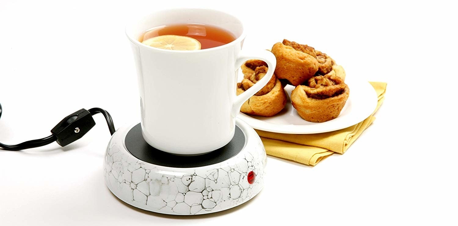 the marble-look mug warmer with a cup of tea on it