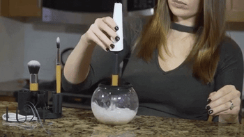 Gif of the brush spinner spinning a makeup brush at a high speed to dry it 