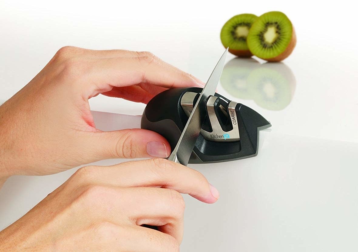 Hands sharpening a knife in the first groove