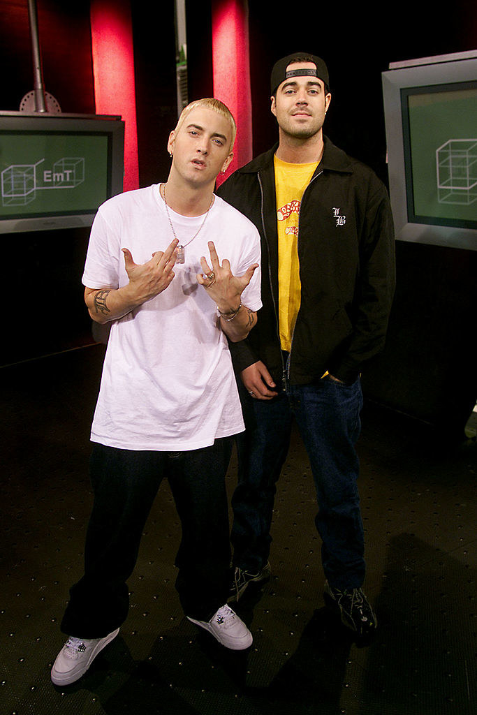 Eminem standing next to Carson Daly on the set of TRL in 2000