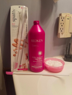 reviewer pic of large bottle of shampoo and a tub of the extra shampoo the spatula got out of the bottle