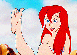 Ariel from The Little Mermaid looking at her foot and wiggling her toes