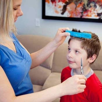 parent using the clip to cut a kid's bangs