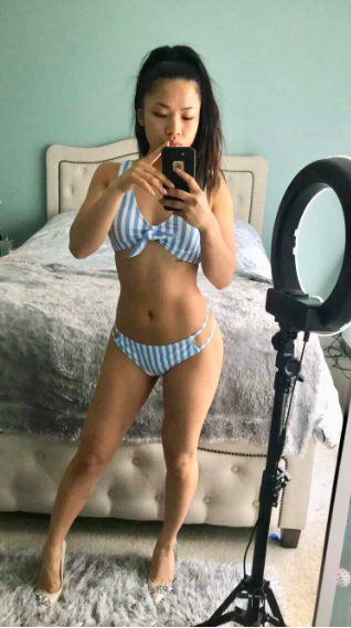 reviewer wearing the light blue and white striped bikini with side cutouts on the bottoms
