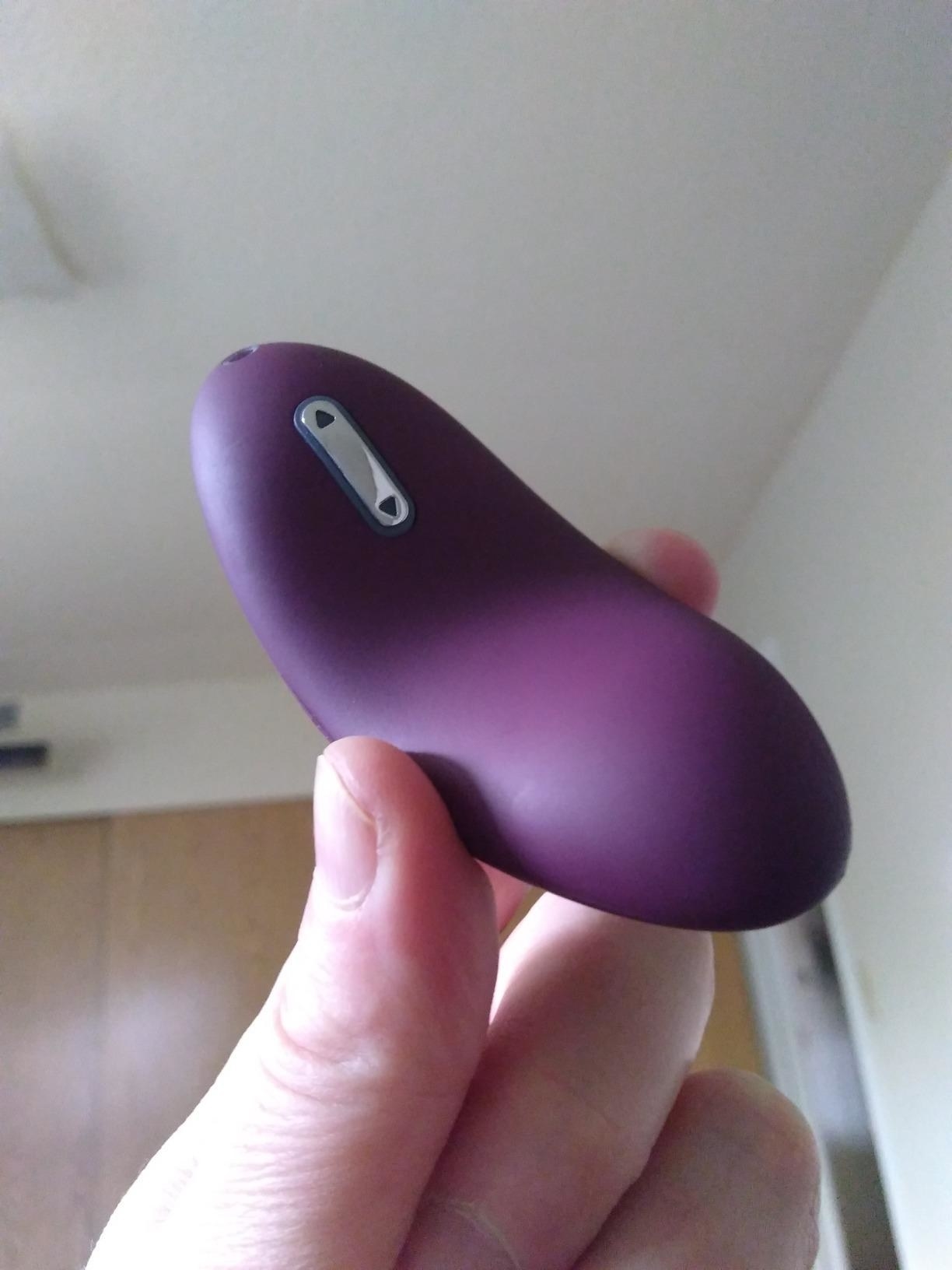 a reviewer holding the small purple vibrator