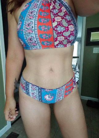 a reviewer in the halter bathing suit with a colorful paisley pattern on it