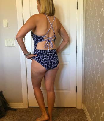 the same reviewer wearing the suit reversed to a navy and white print, showing off the strappy back