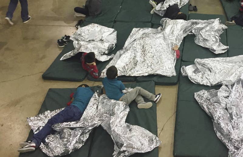 In this June 17, 2018, file photo, people, including children, who have been taken into custody related to cases of unauthorized entry into the United States rest in cages at a facility in McAllen, Texas.