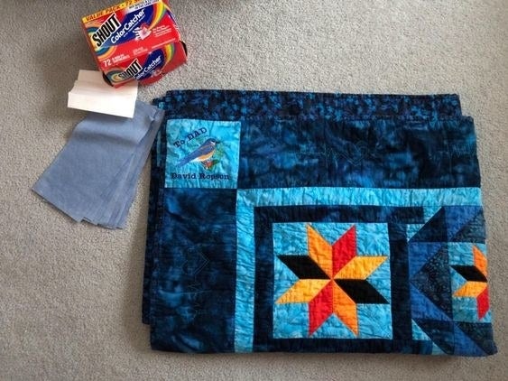 reviewer image of a bright blue quilt next to a box of shout color catcher