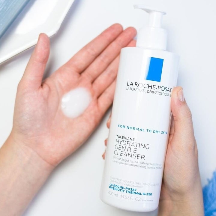 model holding white cleanser bottle with pump top