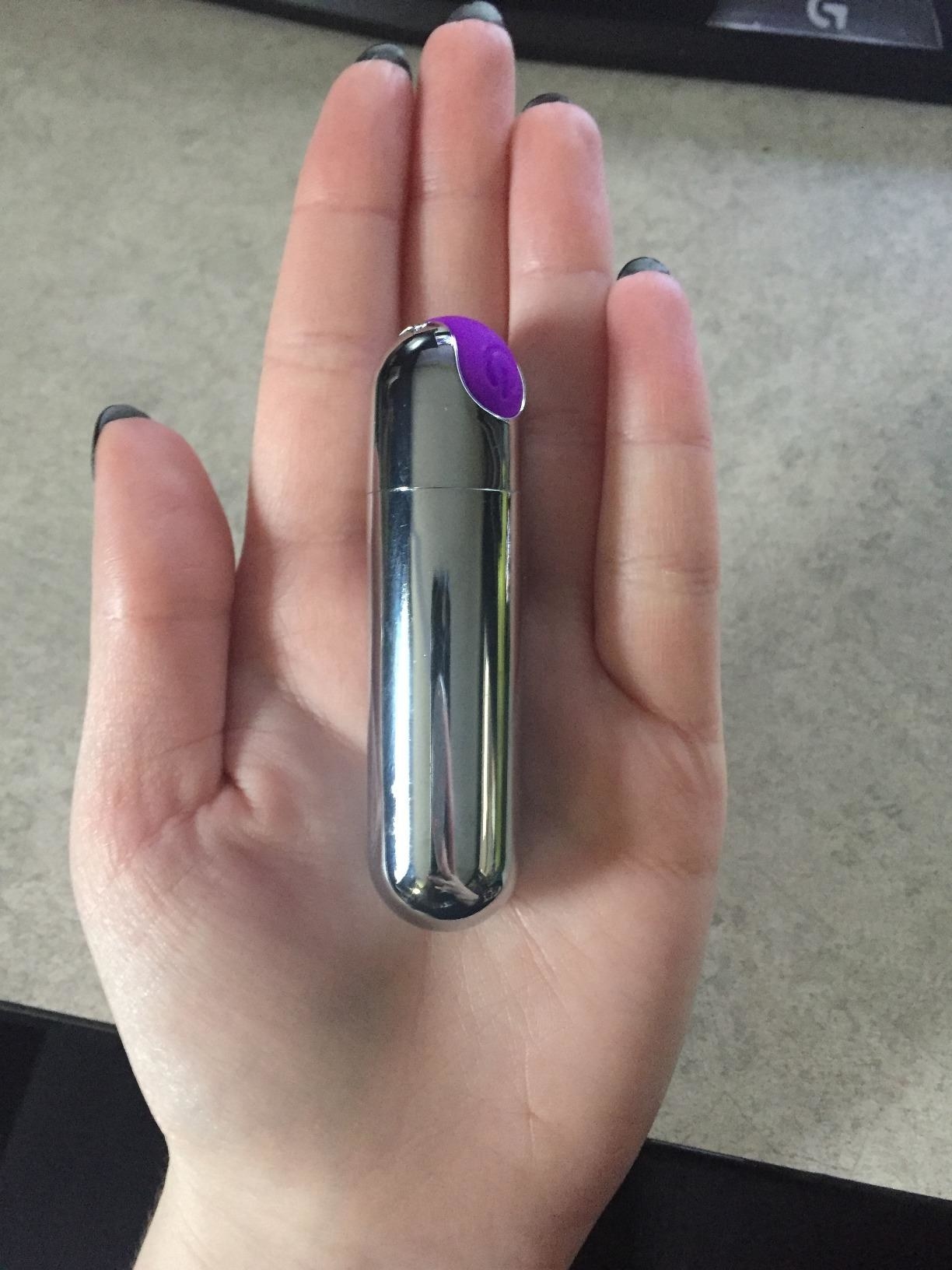 Reviewer holds tiny silver bullet vibe in hand