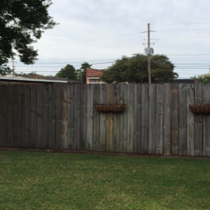reviewer pic of worn, gray looking wood fence from age